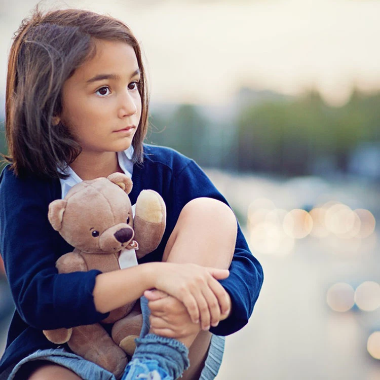 Young girl holding a teddy bear